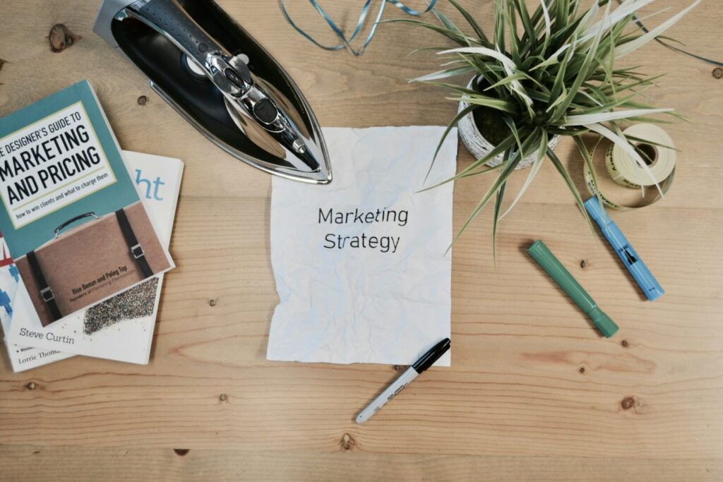 Essential KPIs for a Successful 2025 Marketing Strategy - marketing strategy written on a white paper on a wooden table - Josei Creative Agency